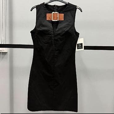 lisice oko vrata: Crna mini haljina bez rukava sa upečatljivim detaljem oko vrata. Model — 1
