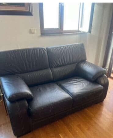 polovne garniture za dnevnu sobu: Ova udobna sofa presvučena kožom u tamnoj boji, verovatno braon ili — 2