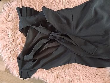 c: Elegantna crna haljina bez rukava, klasičnog kroja do kolena. Model je — 2