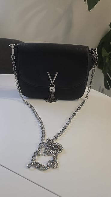 Elegantna crna ženska torbica preko ramena sa srebrnim lancem. Model