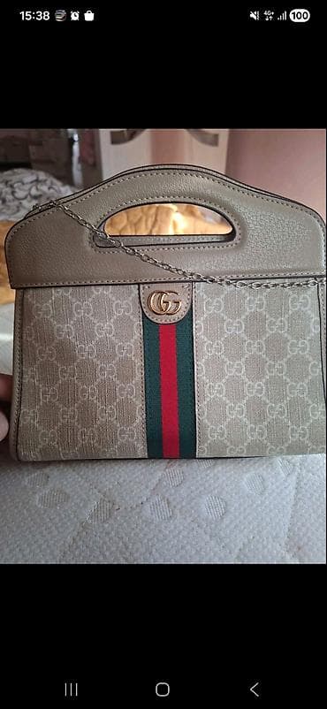 gucci kosulja: Elegantna torbica sa ručkom i lancem preko ramena. Model u bež — 1