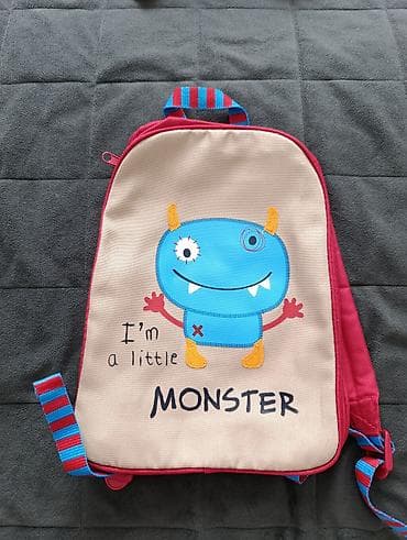 Dečiji ranac bež boje sa aplikacijom plavog čudovišta. Ranac ima