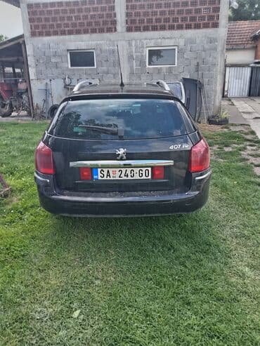 lidl presvlake za auto: Peugeot 407 SW karavan u crnoj boji. Vozilo ima krovne nosače i alu — 3