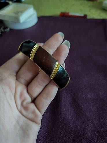 devojka sa bisernom mindjusom slika: Masivna narukvica sa segmentima od tamnog kamena/drveta i — 1