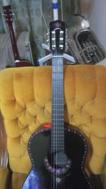 Gitare: Klasična gitara u crnoj boji sa detaljima u obliku cvetova. Opremljena