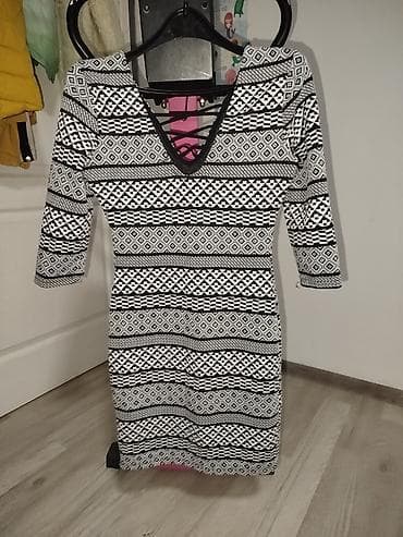 Crno-bela uska haljina sa etno/geomterijskim printom. Model je dužine