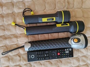 Elektro materijal: Tri ručne lampe različitih modela. Dve su crne sa žutim detaljima i