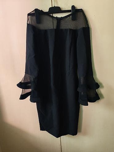 Elegantna crna haljina midi dužine sa transparentnim detaljima. Gornji