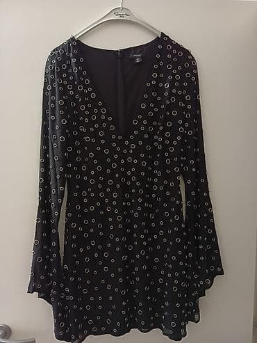 Crna mini haljina sa V-izrezom i zvonastim rukavima. Tkanina je lagana