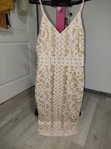 Elegantna midi haljina na tanke bretele, u bež/šampanj nijansi. Model