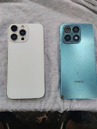 Dva pametna telefona – Apple iPhone (bela zadnja strana) i HONOR
