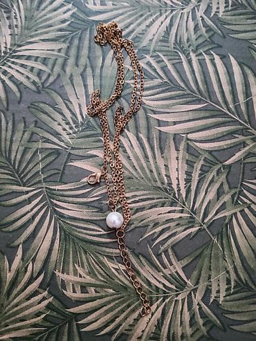 Elegantna ogrlica sa zlatno-toniranim lancem i belim bisernim