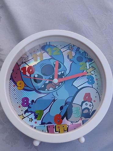 Dečiji budilnik sa belim okruglim okvirom i nogicama. Dizajn