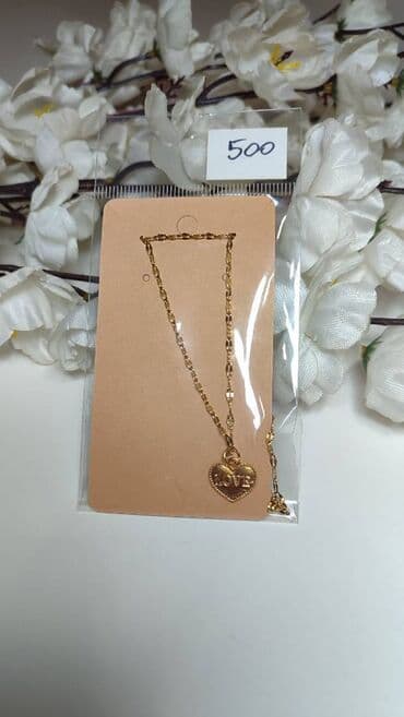 Wallets: Zlatno-tonirana ogrlica sa privjeskom u obliku srca. Lančić je — 1