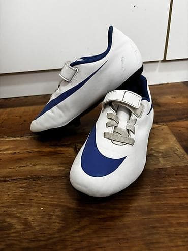beli uniforma: Dečje fudbalske kopačke Nike – bela osnova sa plavim Swoosh logom. - — 2