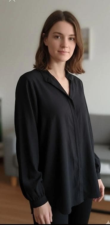 Ženska crna košulja dugih rukava sa kragnom. Karakteriše je opušten