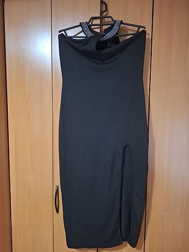 Elegantna crna haljina bez rukava, uskog kroja do kolena. Gornji deo