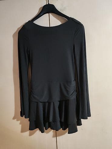 teget suknja: Crna haljina sa dugim rukavima i dubljim izrezom na leđima. Model je — 1