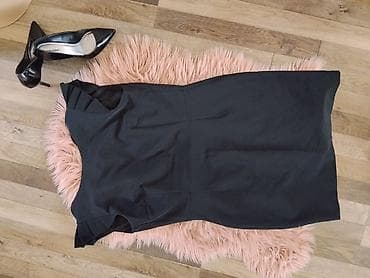 c: Elegantna crna haljina bez rukava, klasičnog kroja do kolena. Model je — 1