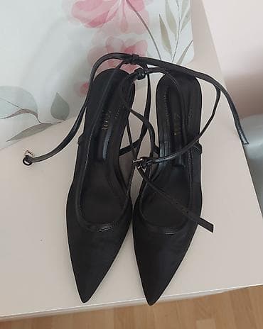 Crne elegantne salonke sa tankom štiklom i kaišićima oko zgloba. -