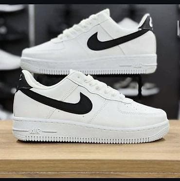 Sandale i papuče: Bele patike niskog profila sa crnim Swoosh logotipom - Model — 1