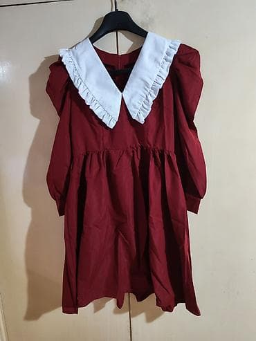 Haljina bordo boje sa belim, širokim kragnom na volane. Model je