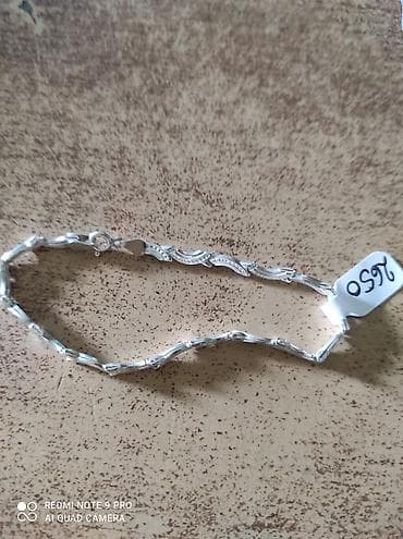 Srebrna narukvica elegantnog, talasastog dizajna. Segmenti su povezani