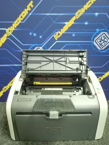 Skeneri: Laserski štampač HP LaserJet 1010, sive i bele boje. Opremljen je