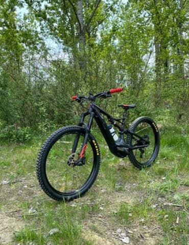 kaciga i naocare za skijanje: Električni brdski bicikl sa crnim okvirom i crvenim detaljima na — 2