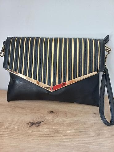 Ženska elegantna torbica/klač crne boje sa zlatnim detaljima. -