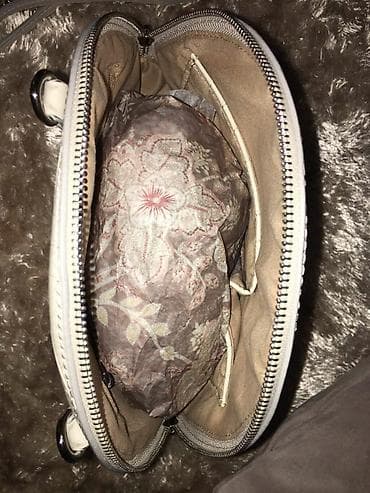 Polukružna crossbody torba u svetloj (krem/beloj) boji sa teksturom