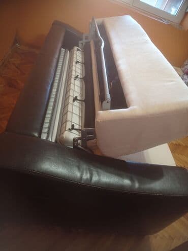 Kožni trosed na razvlačenje. Sedalni deo je prevrnuta koža. Kupljen