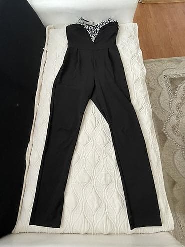 Elegantni crni ženski kombinezon bez rukava. Gornji deo je korset