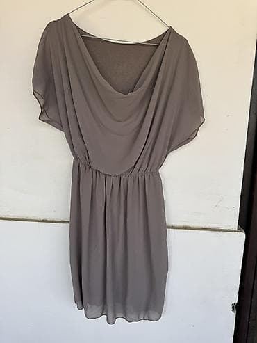 Ženska haljina od laganog šifona u sivo‑taupe nijansi. Model je midi