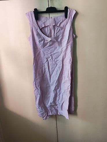 Ženska haljina svetloroze boje, izrađena od lana. Dizajnirana je bez