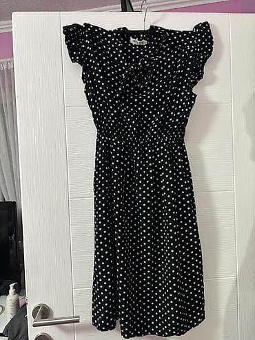 Crna haljina sa belim tufnama, midi dužine. Model sa strukom na lastiš