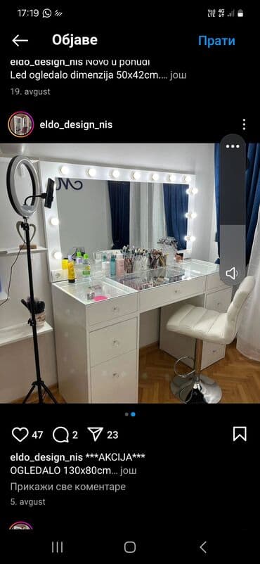 Toaletni sto u beloj boji sa velikim ogledalom okruženim sijalicama