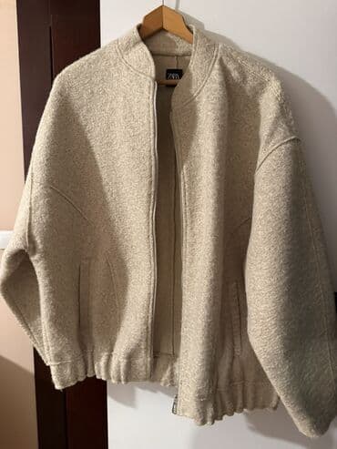 ZARA ženska jakna u bež/boja peska nijansi. Model u stilu