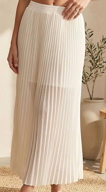 Dugačka ženska suknja bele boje sa plisiranim dizajnom. Karakteriše je