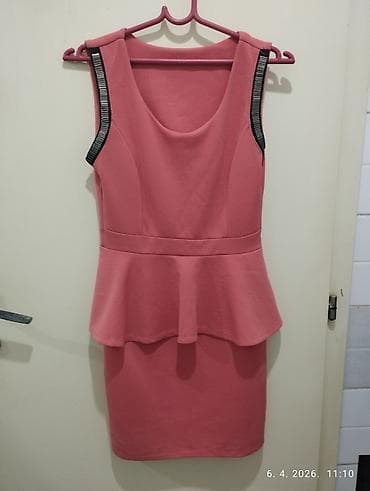 Elegantna ženska haljina bez rukava u puder‑roze/koralnoj boji. Model