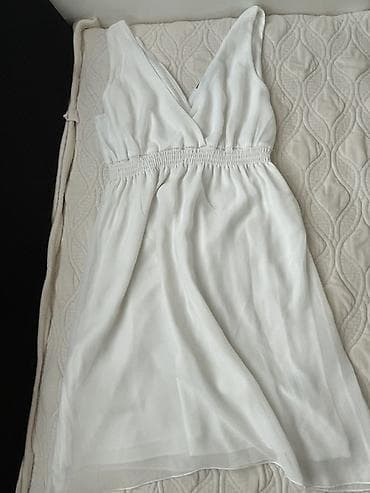 Bela ženska haljina bez rukava, midi/iznad kolena dužine. Model sa