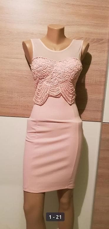 Elegantna ženska haljina u puder‑roze boji, kroja iznad kolena