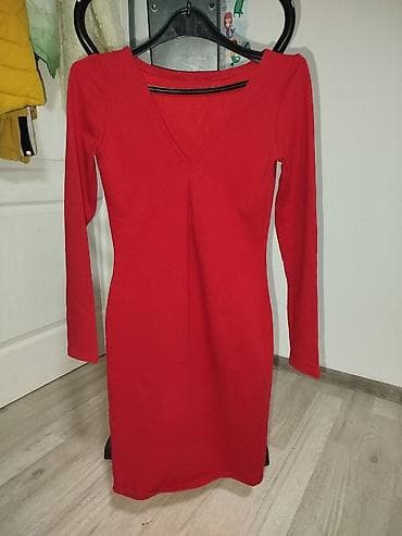 Crvena haljina sa dugim rukavima i V-izrezom. Kroj je pripijen uz