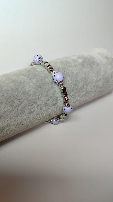 Elegantna ženska narukvica sa svetloljubičastim perlama i metalnim