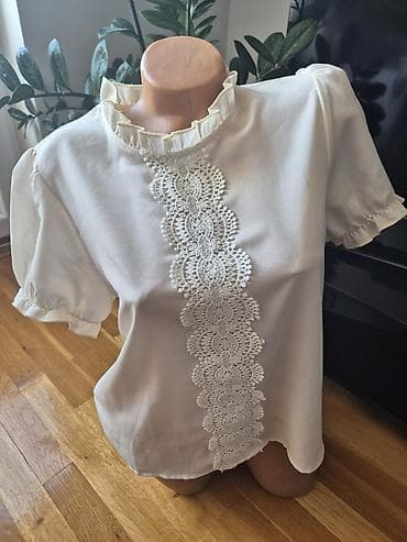 Elegantna krem bluzica sa kratkim puf rukavima i volančićima. Prednji