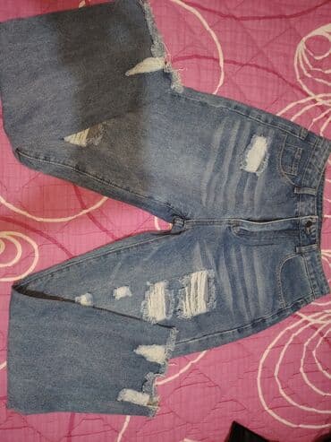 helanke sa visokim strukom: Ženske farmerke sa poderotinama i efektnim izbledelim detaljima. - — 2