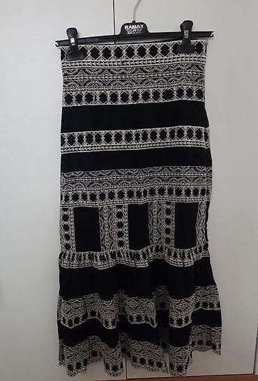 Duga crna suknja sa belim etno/geomterijskim vezom. Model je A-kroja