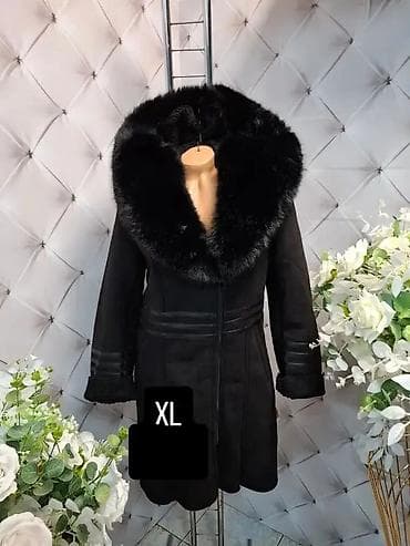 Elegantni crni kaput sa bogatim krznenim okovratnikom. Model do iznad