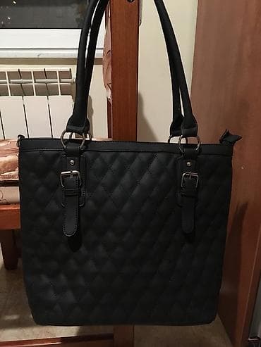 Crna tašna, sa dve pregrade koje se zatvaraju rajsfešlusom i tri džepa