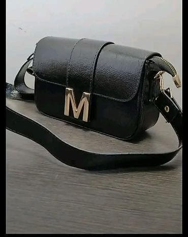 pletene torbe waikiki: Crna ženska torbica preko ramena sa zlatnim slovom “M” na preklopu. - — 2